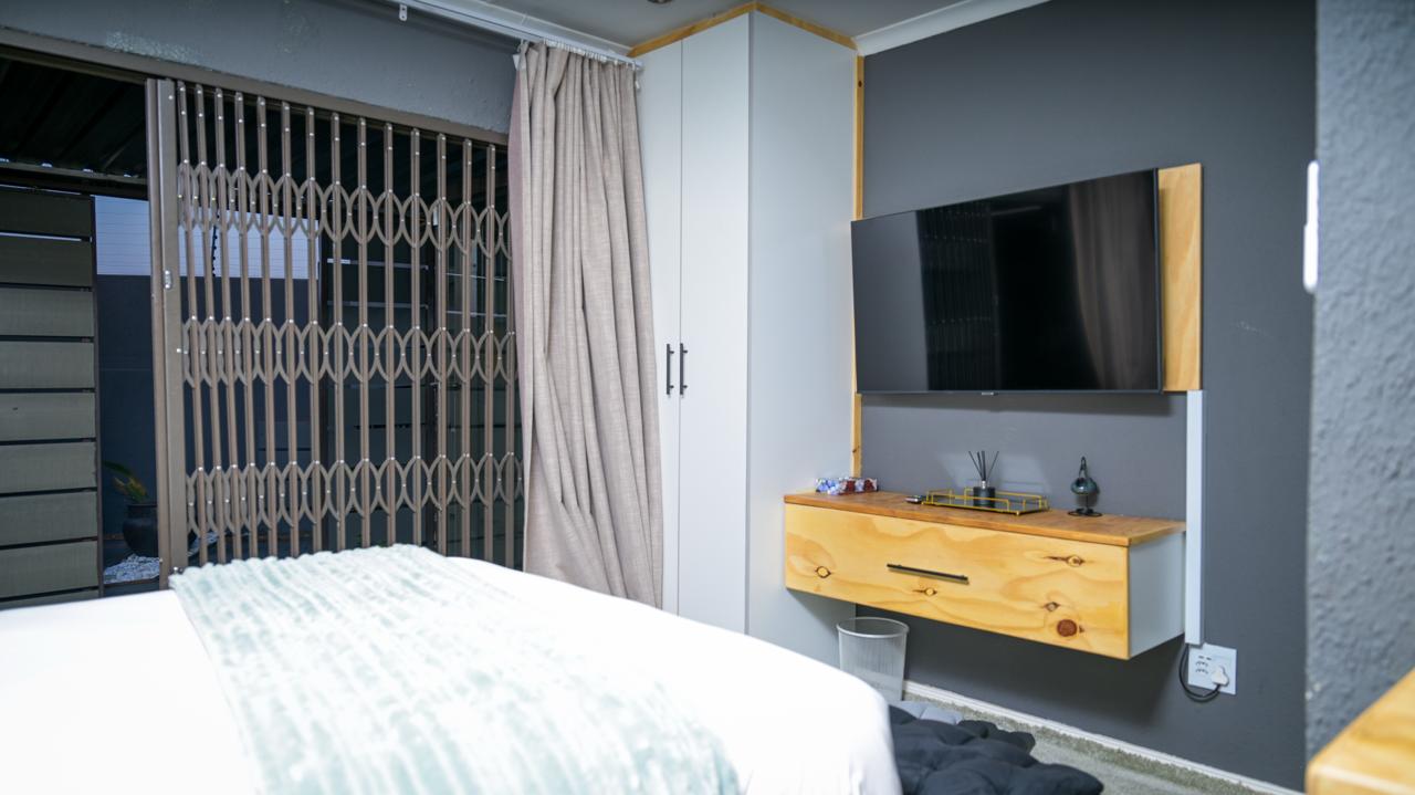 The Bright Room — wardrobe, wall-mounted TV and dresser