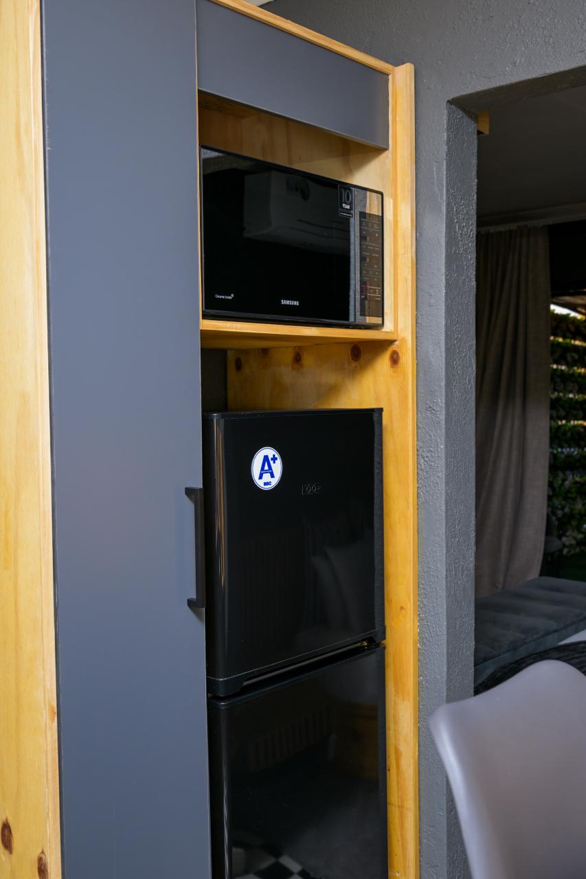 The Dark Room — microwave and fridge nook in the kitchenette