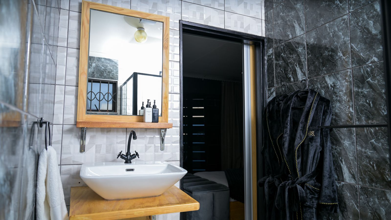 The Dark Room — bathroom vanity, mirror and bathrobes