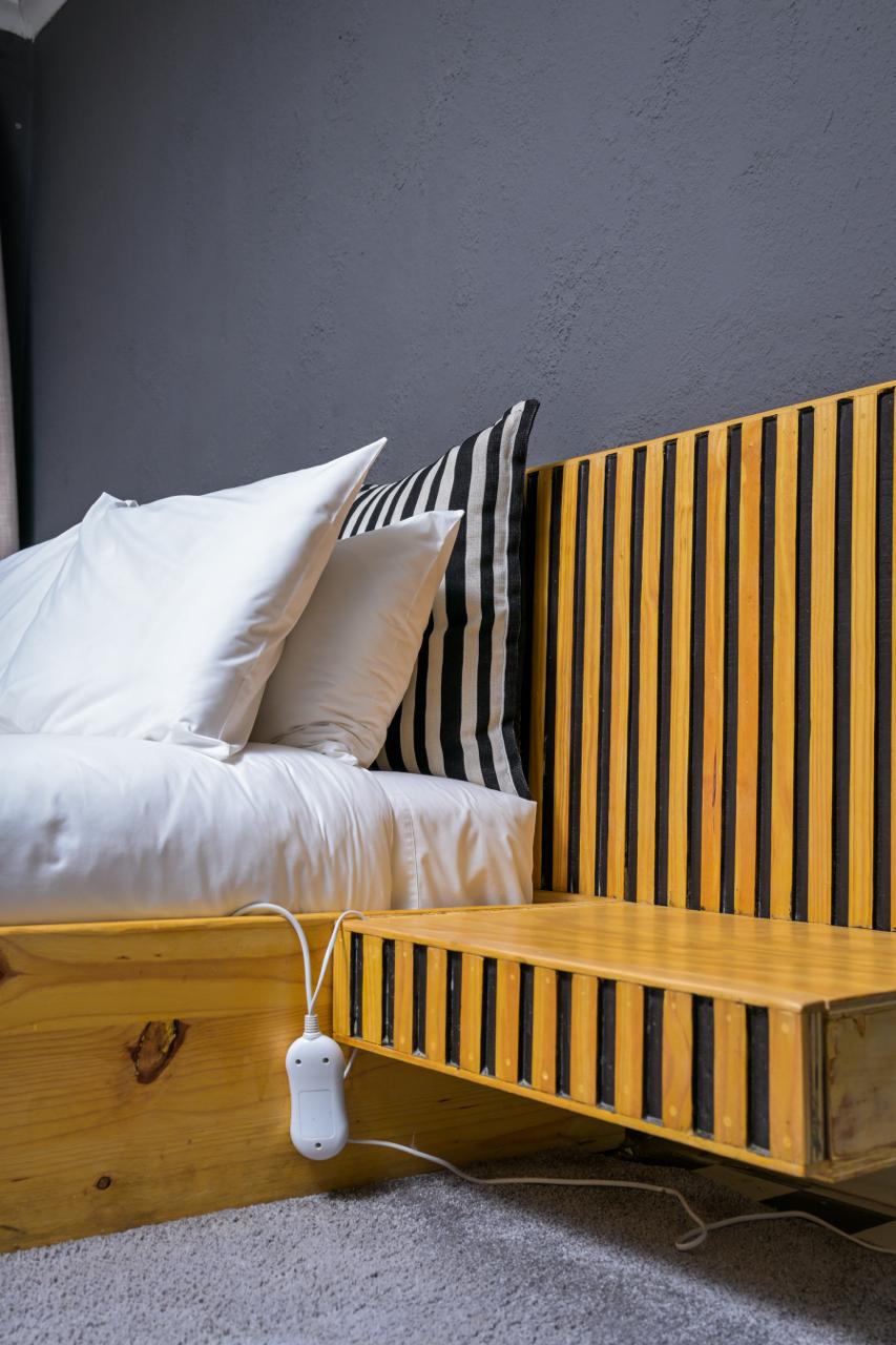 The Dark Room — bedside detail with slatted timber headboard