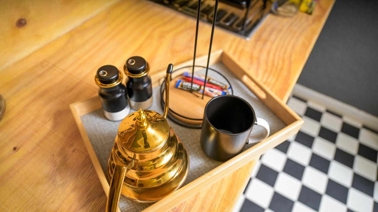 The Dark Room — brass kettle, mugs and refreshments on a wooden tray