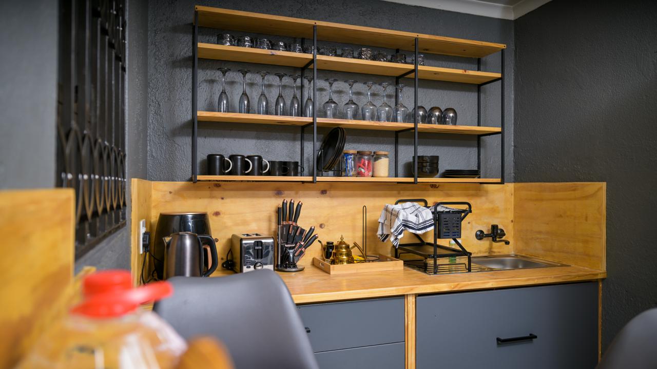 The Dark Room — kitchenette with stocked shelves, glassware and sink