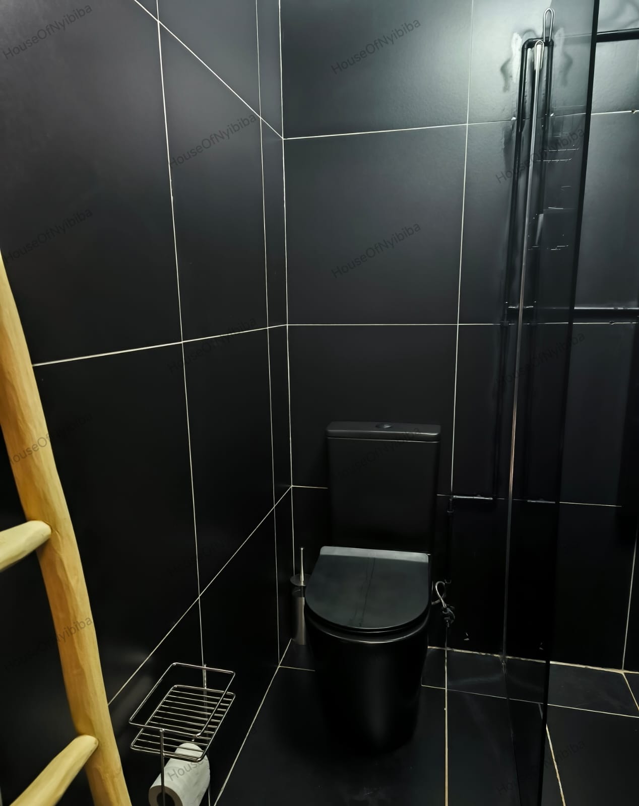 Zululami — sleek black-tiled en-suite bathroom with toilet and shower