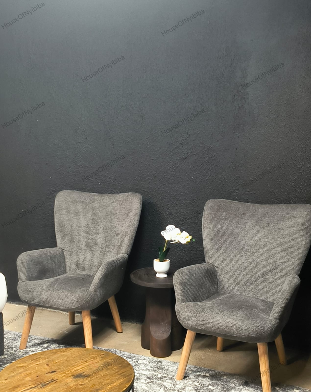 Zululami — two grey wing chairs with an orchid on the side table