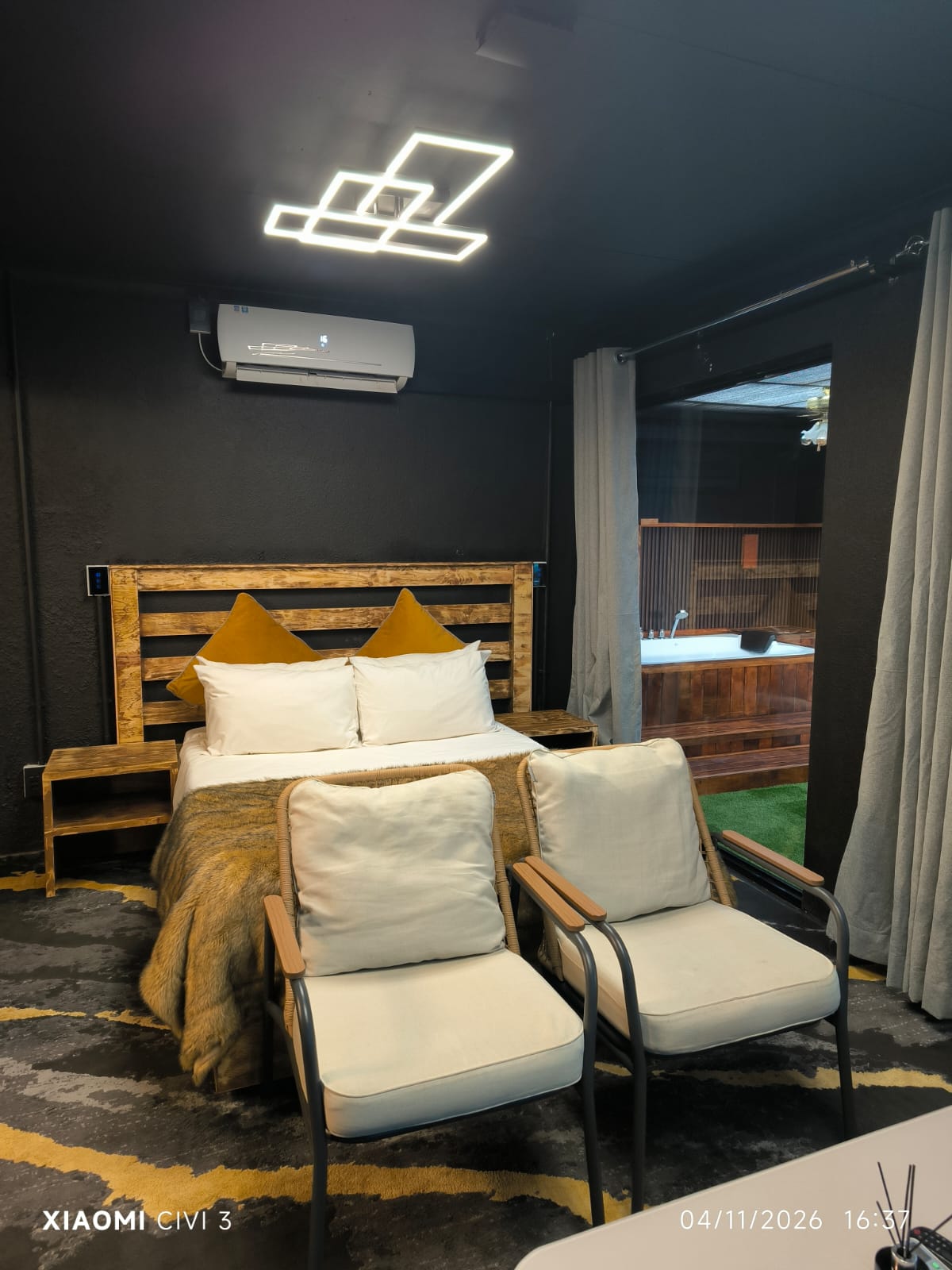 The Mihla Room — queen bed with a view onto the terrace hot tub